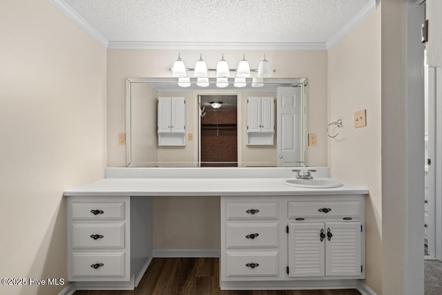 bathroom featuring vanity, a textured ceiling, ornamental molding, and wood finished floors