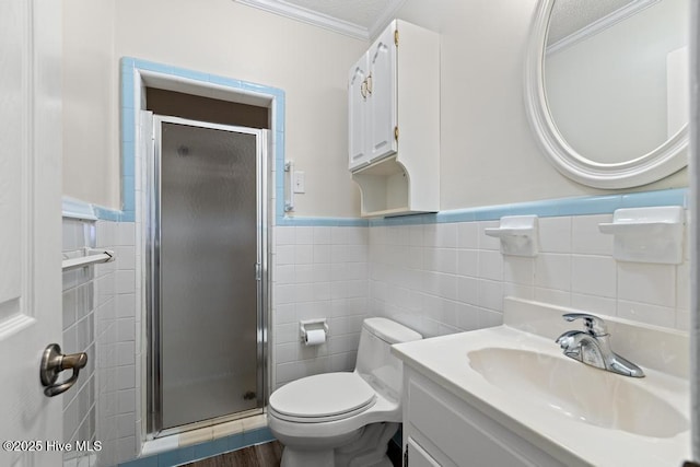 bathroom with a wainscoted wall, tile walls, ornamental molding, and a stall shower