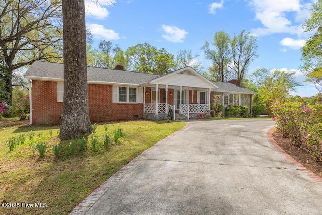 ranch-style home featuring brick siding, concrete driveway, covered porch, and a chimney