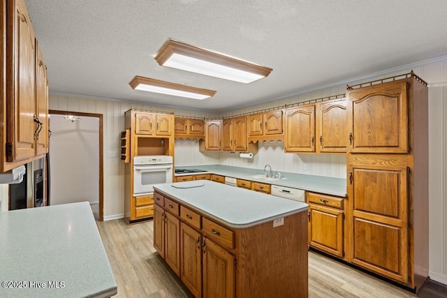 kitchen featuring light countertops, white appliances, and light wood-style floors