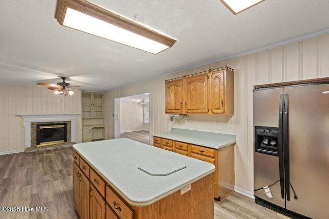 kitchen featuring stainless steel fridge with ice dispenser, light countertops, ceiling fan, and light wood-type flooring