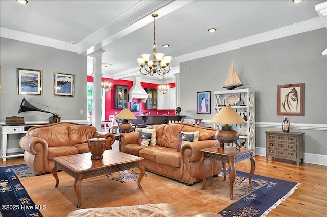 living area featuring baseboards, a notable chandelier, ornate columns, wood finished floors, and ornamental molding