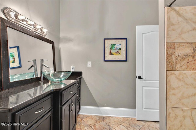full bath with marble finish floor, vanity, and baseboards