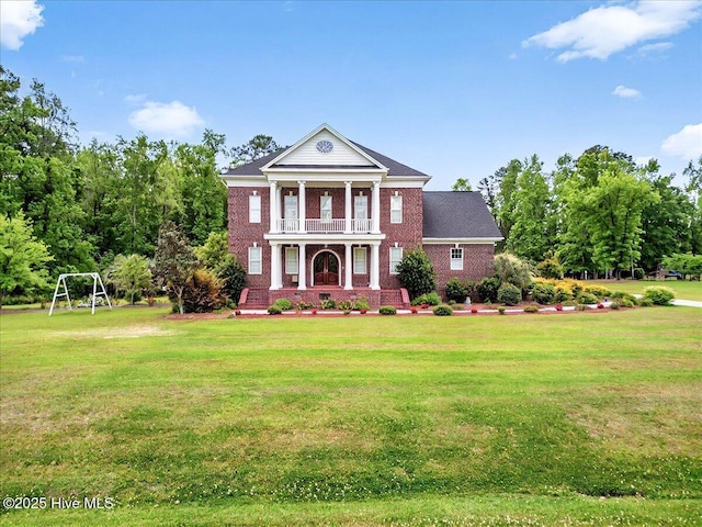 neoclassical home with a porch, a front lawn, a balcony, and brick siding