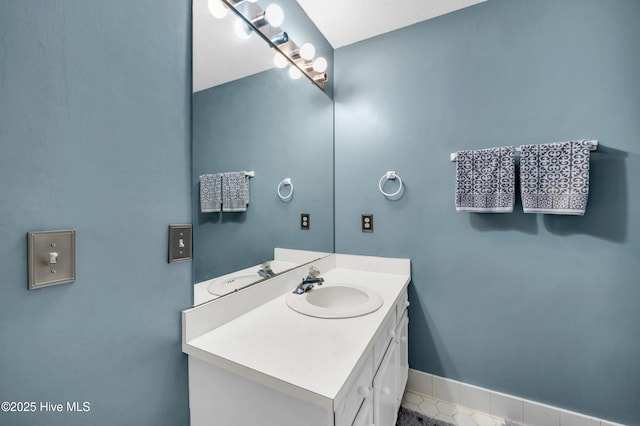 bathroom with vanity, baseboards, and tile patterned flooring