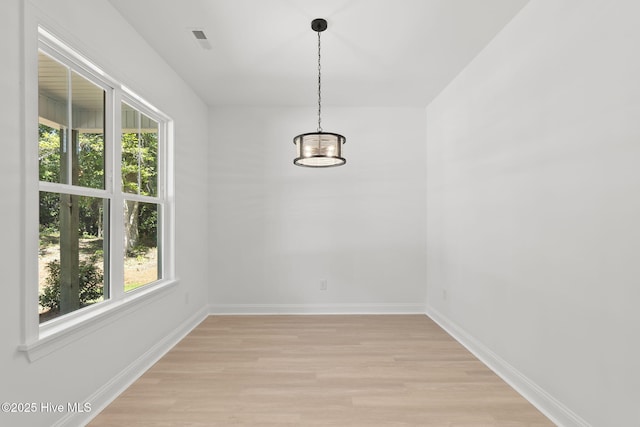 341 Mccabe Rd, Morehead City, NC 28557 - unfurnished dining area featuring a notable chandelier, baseboards, a healthy amount of sunlight, and light wood-style floors