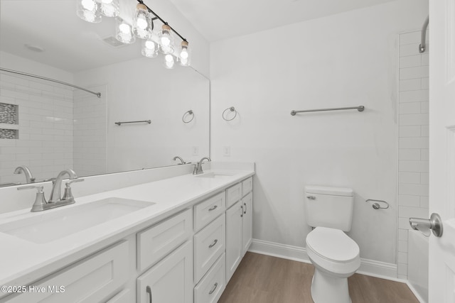 341 Mccabe Rd, Morehead City, NC 28557 - bathroom with double vanity, toilet, wood finished floors, and a sink