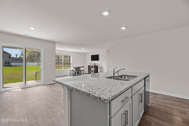 409 King Creek Dr, Havelock, NC 28532 - kitchen with wood finished floors, light stone countertops, recessed lighting, dishwasher, and an island with sink