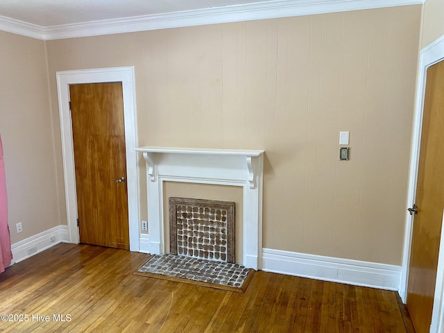 unfurnished living room with baseboards, ornamental molding, wood finished floors, and a fireplace