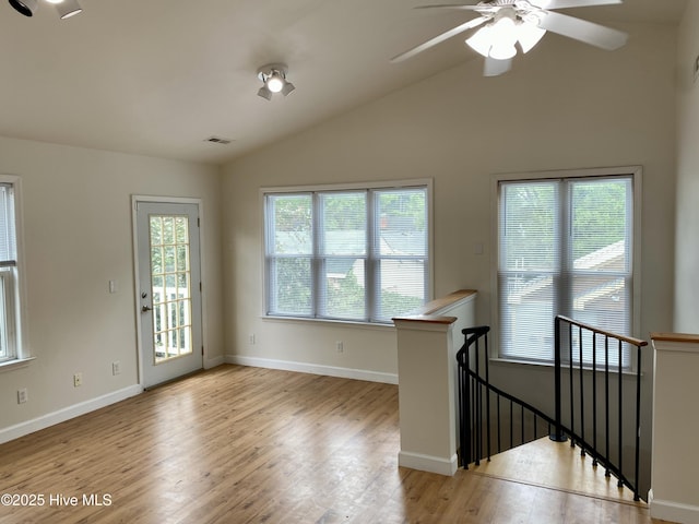 unfurnished room with ceiling fan, visible vents, baseboards, wood finished floors, and vaulted ceiling