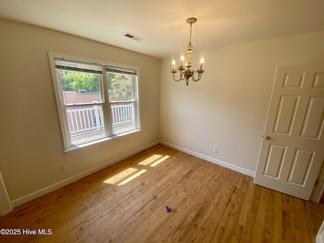 interior space featuring light wood-style floors, baseboards, a notable chandelier, and visible vents