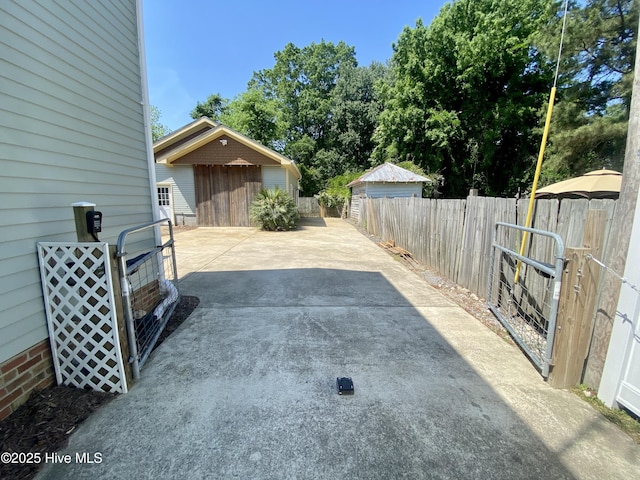 view of patio featuring driveway and fence