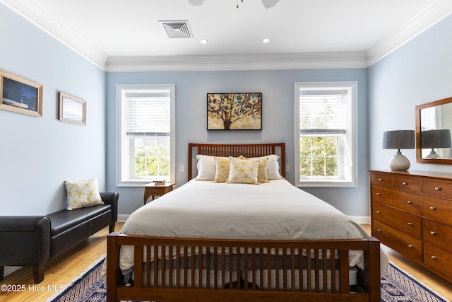 bedroom featuring visible vents, multiple windows, ornamental molding, and light wood-style flooring