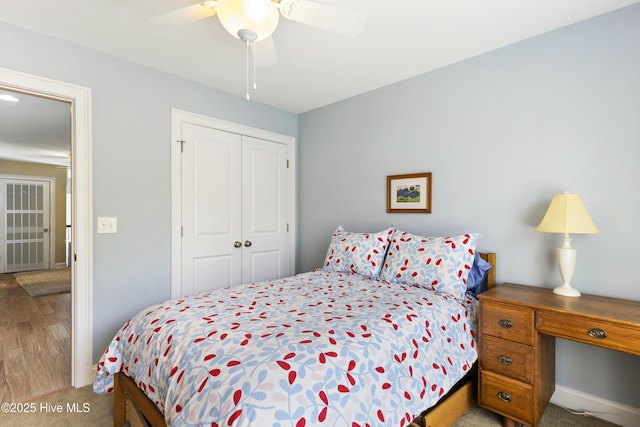 bedroom featuring a closet, wood finished floors, and ceiling fan