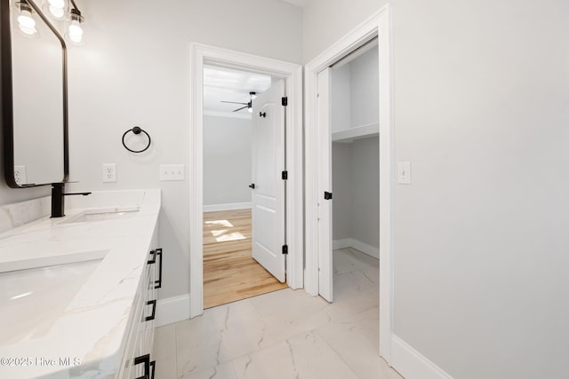 bathroom with marble finish floor, baseboards, a ceiling fan, and a sink