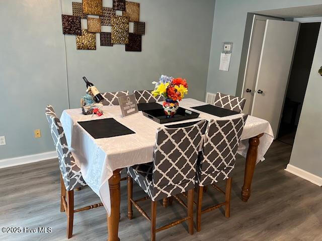 dining space featuring baseboards and wood finished floors