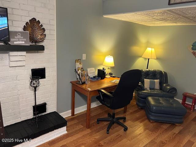 home office with baseboards and wood finished floors