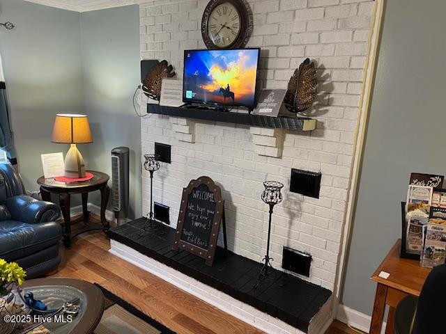 living room featuring baseboards, a fireplace, and wood finished floors