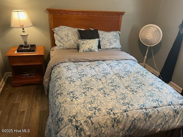 bedroom featuring baseboards and wood finished floors