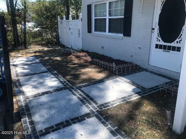 exterior space featuring brick siding and fence