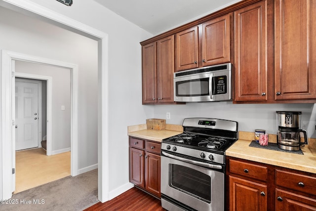 kitchen featuring light countertops, baseboards, and appliances with stainless steel finishes