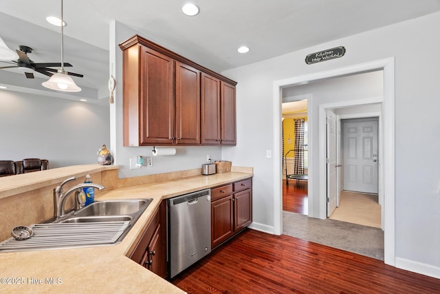 kitchen with a sink, light countertops, a ceiling fan, dark wood-style floors, and stainless steel dishwasher