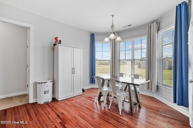dining room with wood finished floors, baseboards, and visible vents