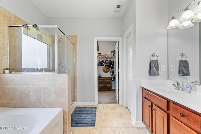 full bath with a garden tub, a shower stall, vanity, a spacious closet, and visible vents