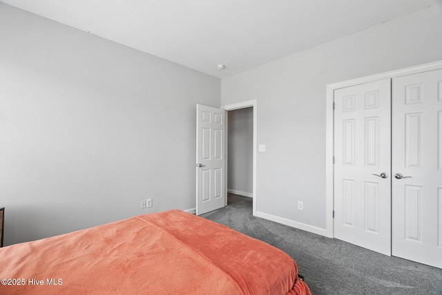 bedroom featuring a closet, dark colored carpet, and baseboards