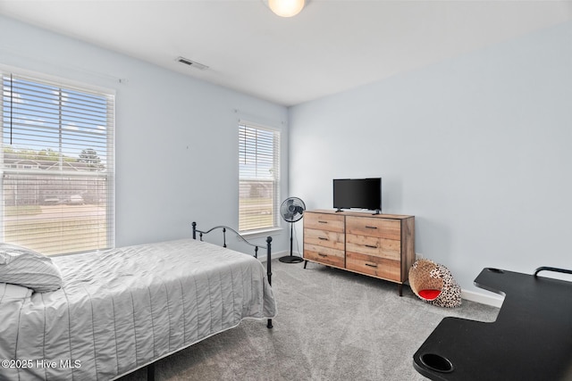 carpeted bedroom featuring visible vents and baseboards
