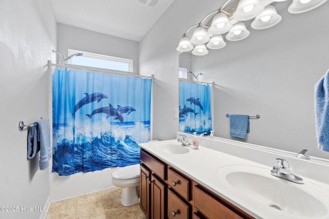 bathroom with double vanity, baseboards, a sink, and toilet