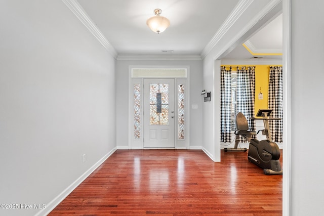 entrance foyer with crown molding, wood finished floors, and baseboards
