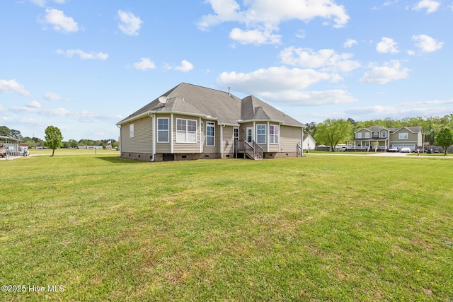 rear view of house with crawl space and a lawn