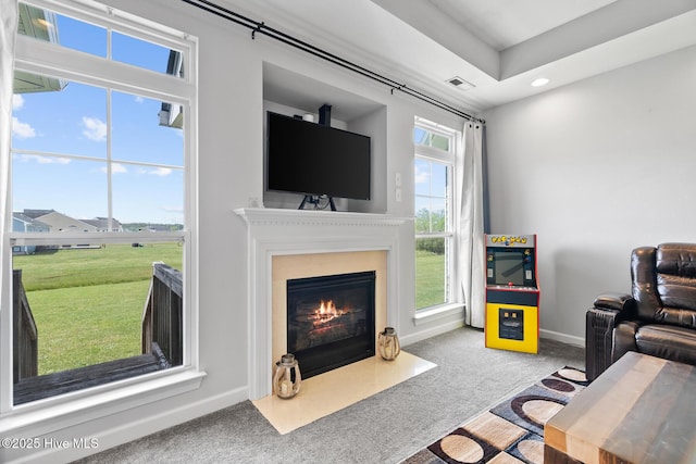 living area featuring visible vents, baseboards, recessed lighting, a fireplace with flush hearth, and carpet flooring
