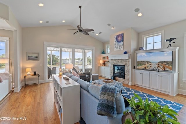 2821 Harborside Way, Southport, NC 28461 - living area with a ceiling fan, a stone fireplace, light wood-style flooring, baseboards, and high vaulted ceiling