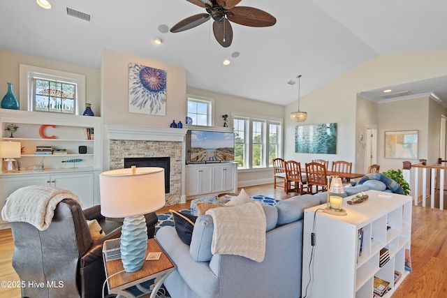 2821 Harborside Way, Southport, NC 28461 - living area with lofted ceiling, light wood-style flooring, ceiling fan, a stone fireplace, and recessed lighting