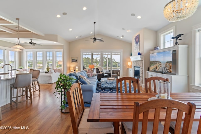 2821 Harborside Way, Southport, NC 28461 - dining space with a ceiling fan, light wood-style flooring, a fireplace, healthy amount of natural light, and vaulted ceiling