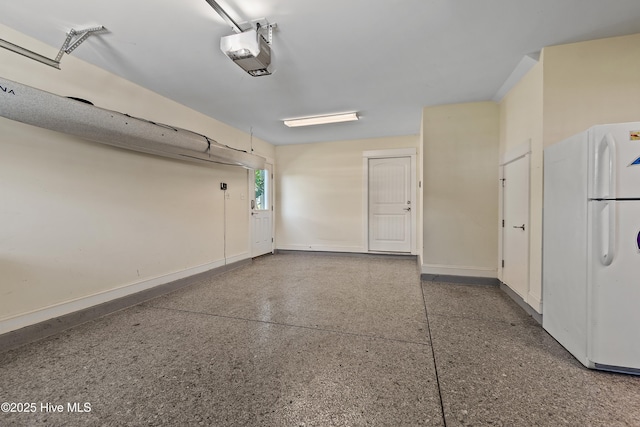 2821 Harborside Way, Southport, NC 28461 - garage with freestanding refrigerator, a garage door opener, and baseboards