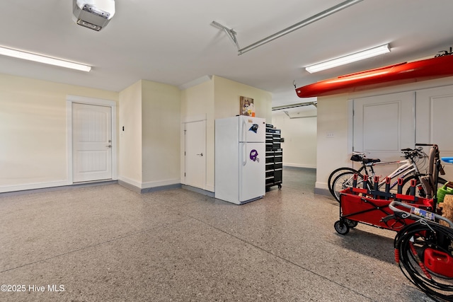 2821 Harborside Way, Southport, NC 28461 - garage featuring freestanding refrigerator, a garage door opener, and baseboards