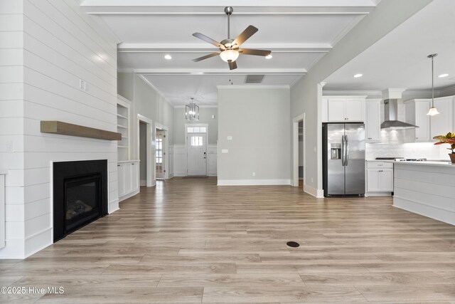 1331 Landover Dr SW, Ocean Isle Beach, NC 28469 - unfurnished living room featuring ornamental molding, ceiling fan, a fireplace, light wood-style flooring, and beamed ceiling