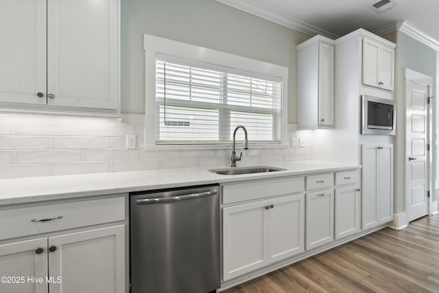 1331 Landover Dr SW, Ocean Isle Beach, NC 28469 - kitchen featuring appliances with stainless steel finishes, a sink, ornamental molding, white cabinets, and decorative backsplash
