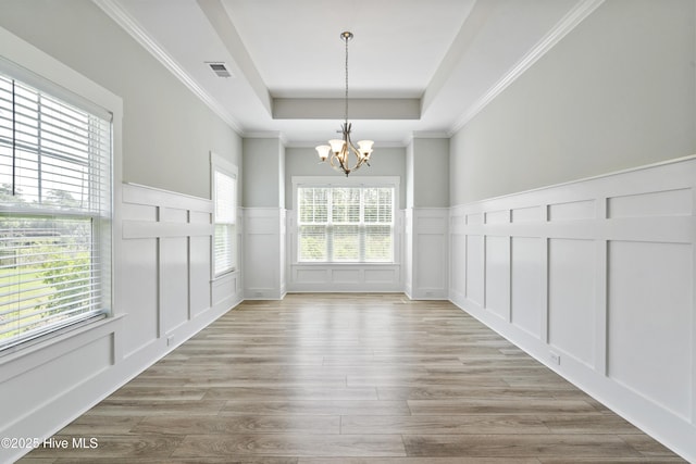 1331 Landover Dr SW, Ocean Isle Beach, NC 28469 - unfurnished dining area featuring a decorative wall, a raised ceiling, a chandelier, wainscoting, and wood finished floors