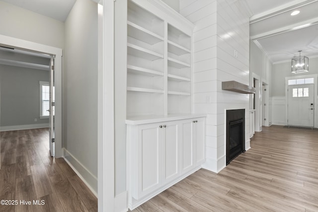 1331 Landover Dr SW, Ocean Isle Beach, NC 28469 - hallway featuring crown molding, light wood-type flooring, a chandelier, healthy amount of natural light, and baseboards