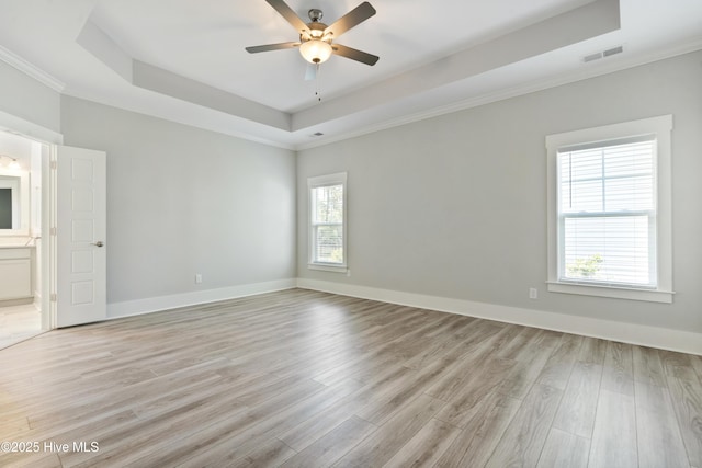 1331 Landover Dr SW, Ocean Isle Beach, NC 28469 - spare room featuring a tray ceiling, light wood-style flooring, a ceiling fan, ornamental molding, and baseboards
