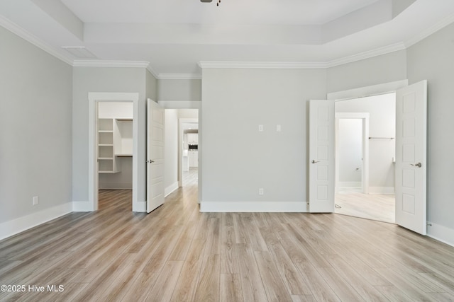 1331 Landover Dr SW, Ocean Isle Beach, NC 28469 - unfurnished bedroom featuring light wood-type flooring, a walk in closet, ornamental molding, baseboards, and ensuite bathroom