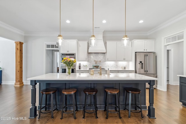 580 Jackline Dr, Hampstead, NC 28443 - kitchen with white cabinets, light countertops, appliances with stainless steel finishes, custom range hood, and backsplash
