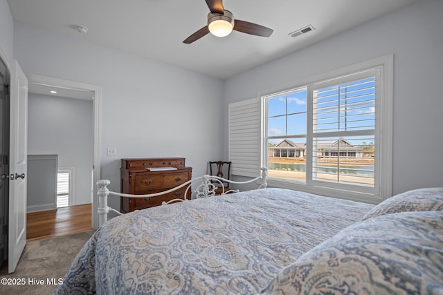 bedroom with carpet floors, visible vents, and a ceiling fan