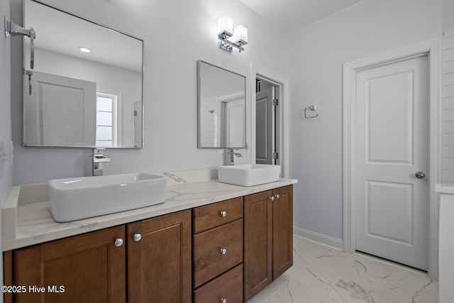 full bathroom with marble finish floor, a sink, and double vanity