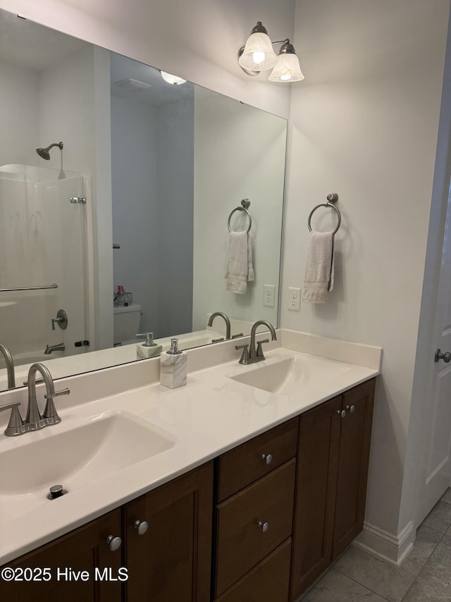 bathroom with double vanity, tile patterned flooring, baseboards, and a sink