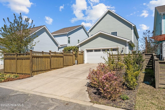 view of front of house with a gate, an attached garage, driveway, and fence
